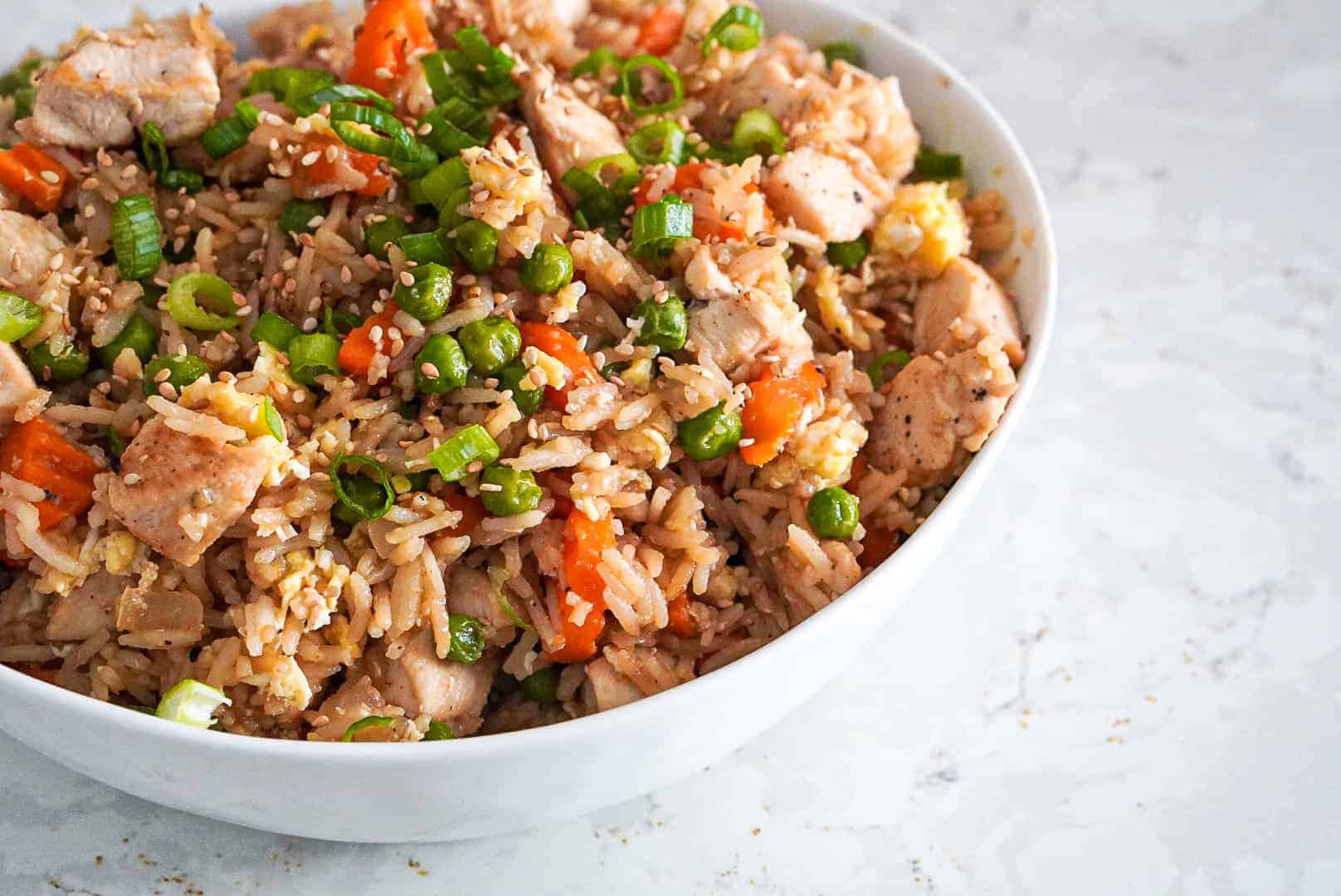 Chicken fried rice in a white bowl.