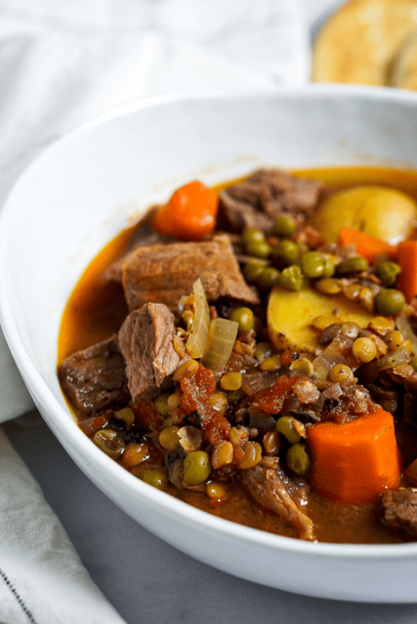Beef and lentil stew piled high in a white bowl.