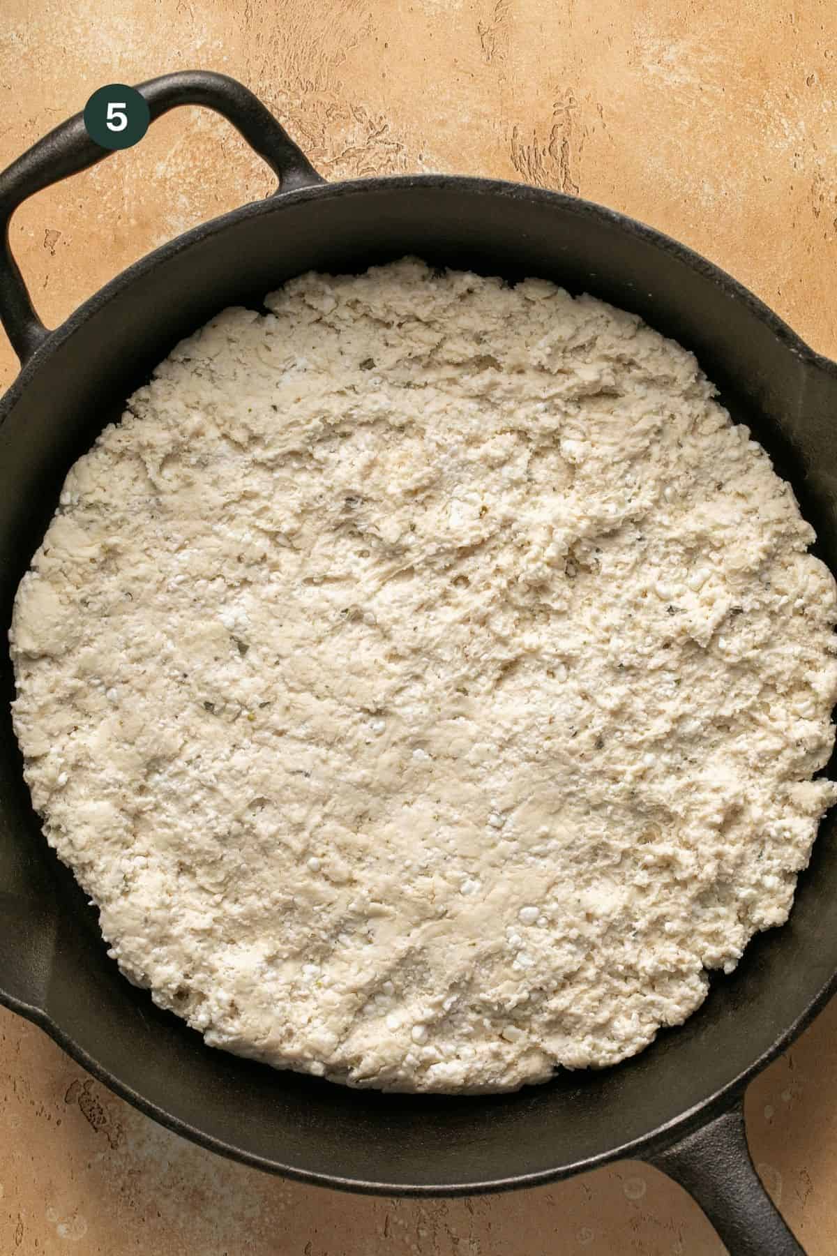 Dough placed in the cast iron and pushed to the outer edges. 
