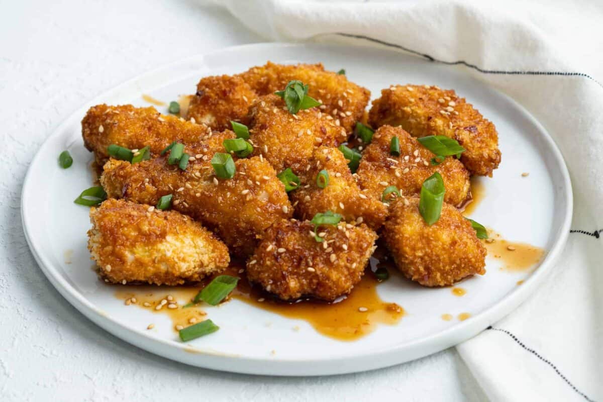 Sesame chicken on a white plate.