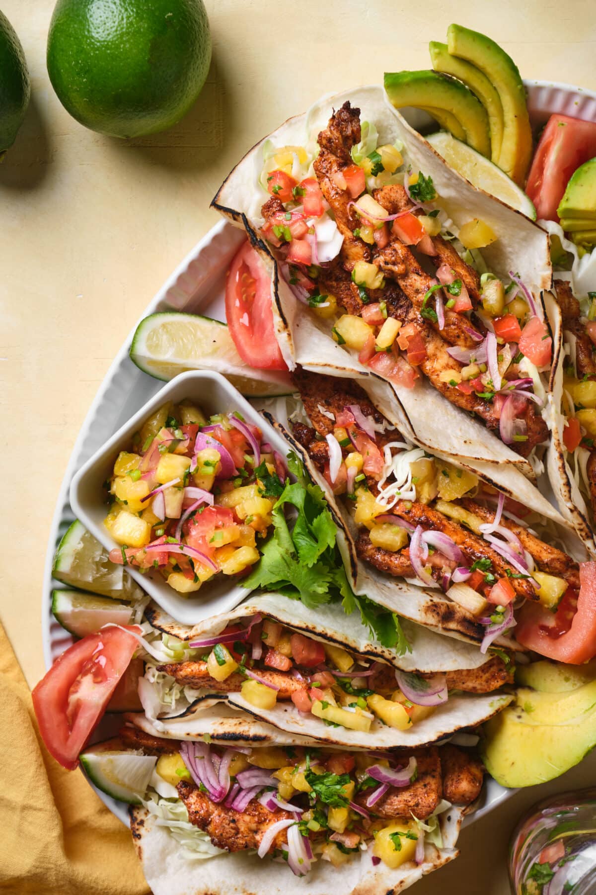 Tacos with blackened chicken, pineapple salsa and avocado plated. 
