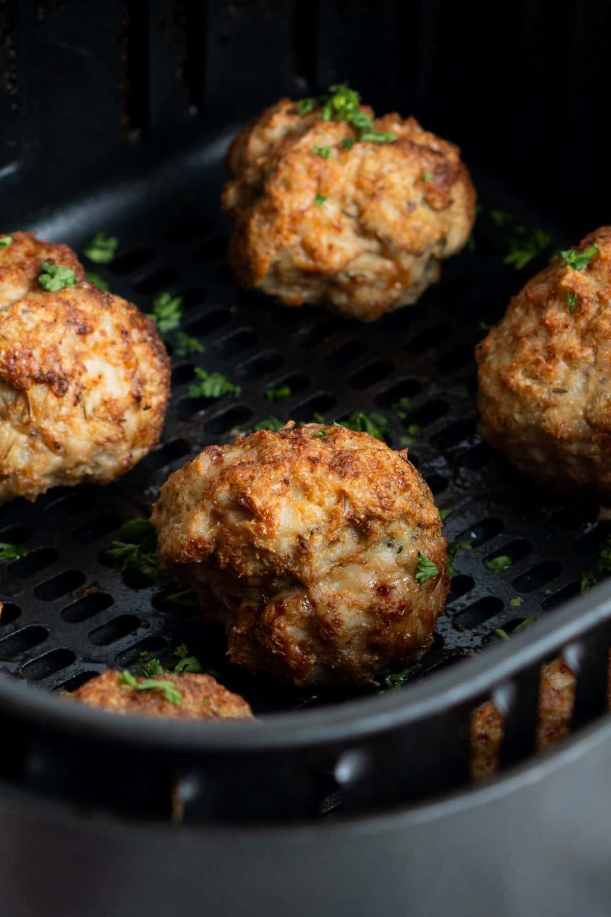 Meatballs in the base of the air fryer basket. 