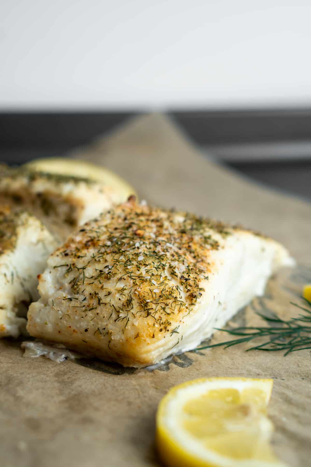 Parchment paper topped with halibut.