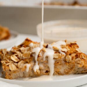 Protein frosting drizzling onto a slice of pumpkin French toast casserole.