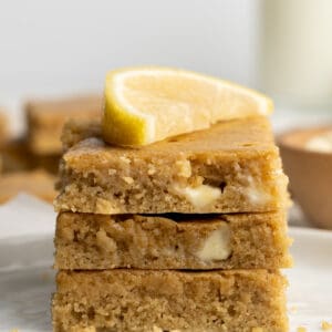 Stack of lemon blondies topped with a lemon wedge.