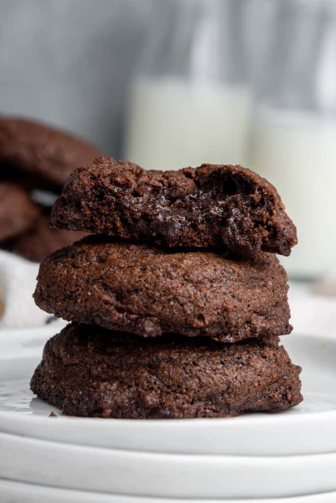Stack of double chocolate protein cookies, one of which is missing a bite.