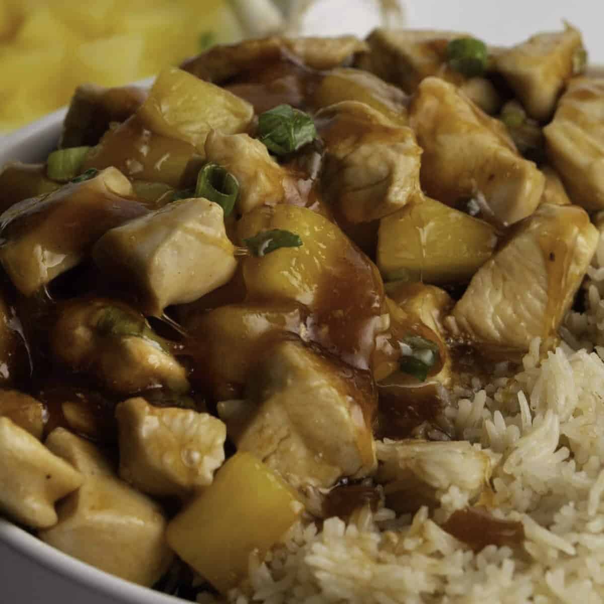 Sweet and sour chicken without breading in a bowl with white rice.