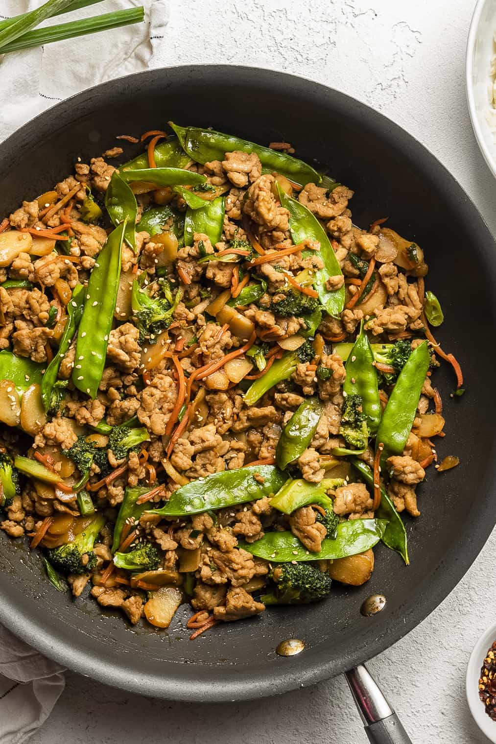 Stir fry in a pan with ground chicken and vegetables. 