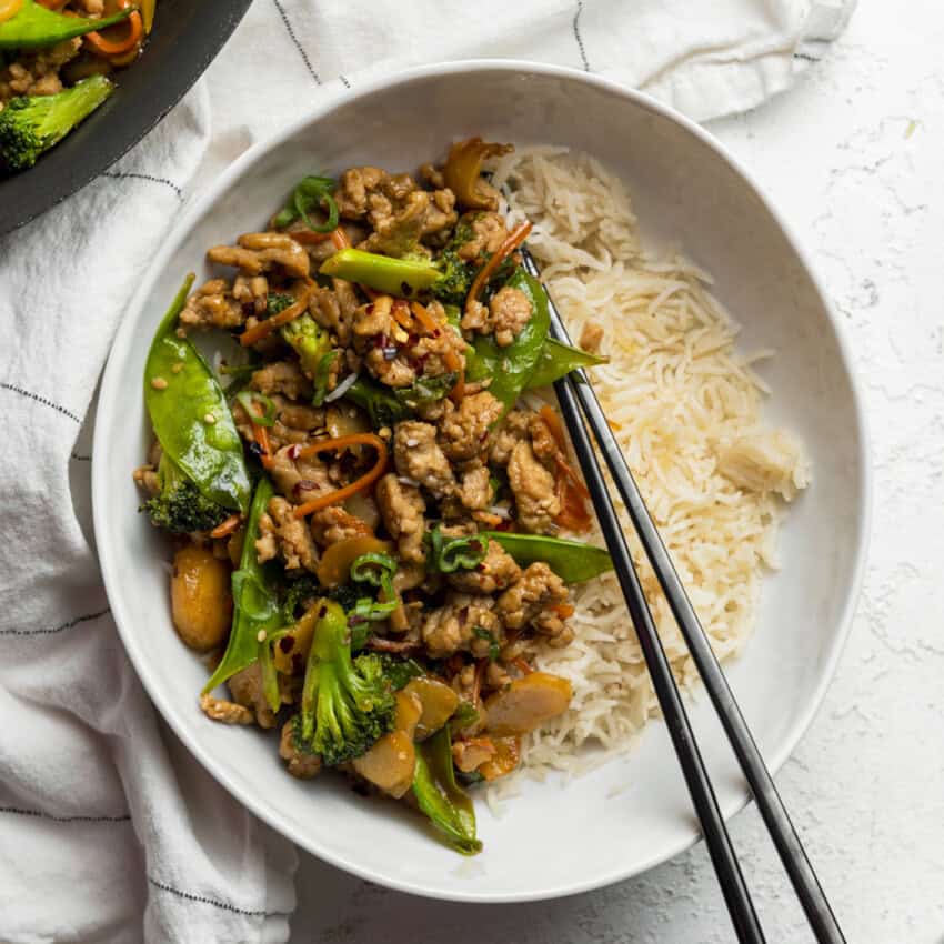 Stir fry in a bowl with chop sticks.