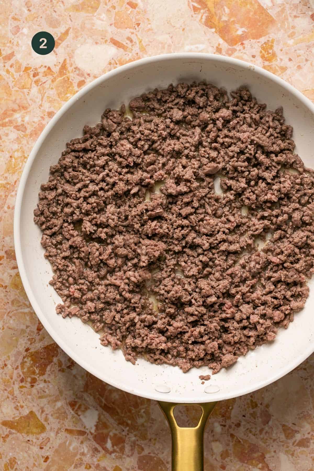 Brown ground beef in a skillet.