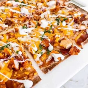 Sliced barbeque chicken pizza on a white plate.