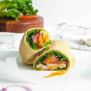 Halved honey mustard chicken wrap on parchment paper.