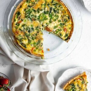 Vegetable quiche on a plate and in a glass pie tin.