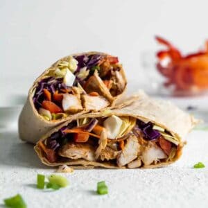 Stacked halves of a peanut chicken wrap.