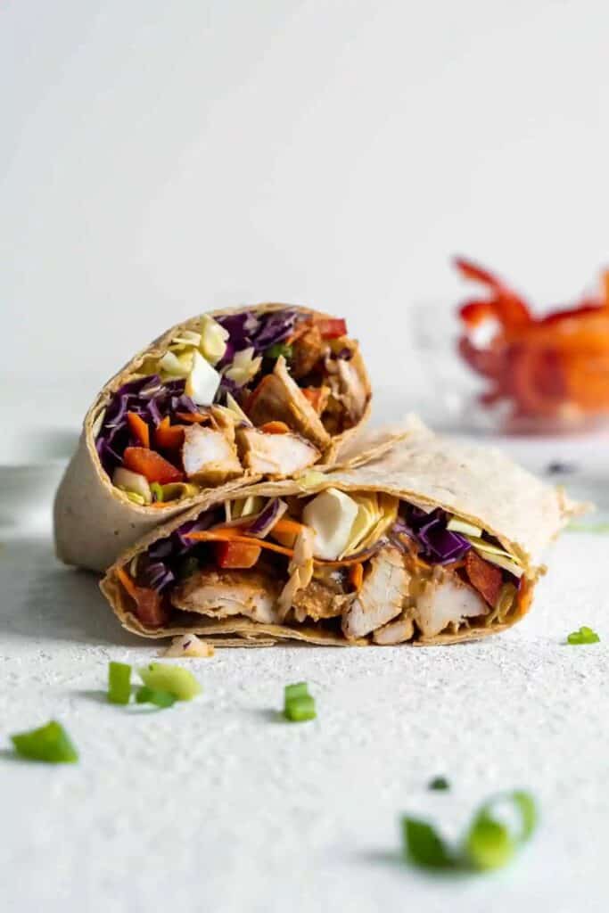 Stacked halves of a peanut chicken wrap.