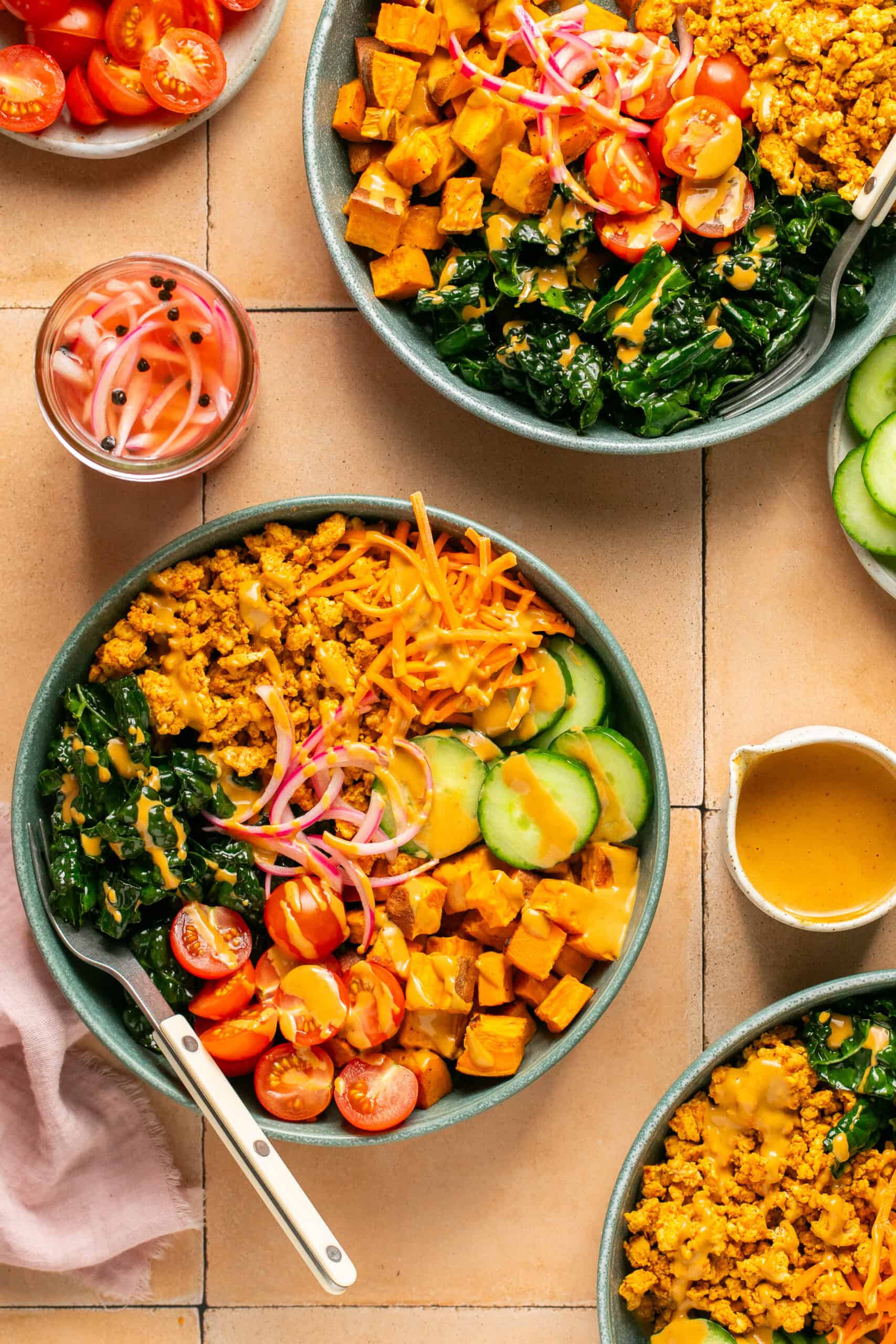 3 assembled ground turkey bowl with tomato, cucumber, kale, pickled red onion and peanut sauce.