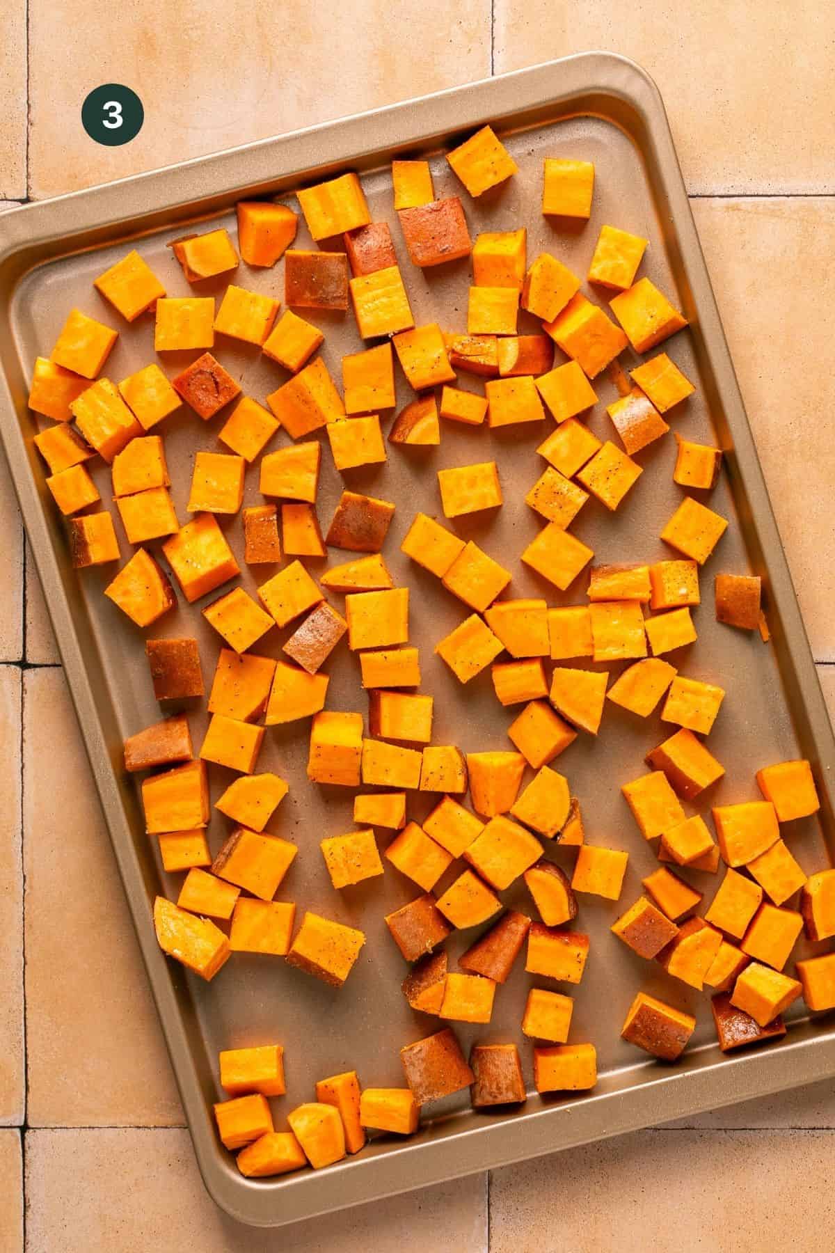 Cubed sweet potatoes on a roasting pan. 