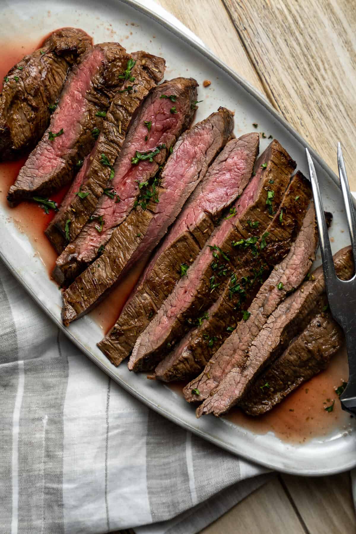 Sliced flank steak on a serving platter.
