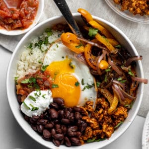 Breakfast burrito bowl with beans, egg, vegetables, and more.