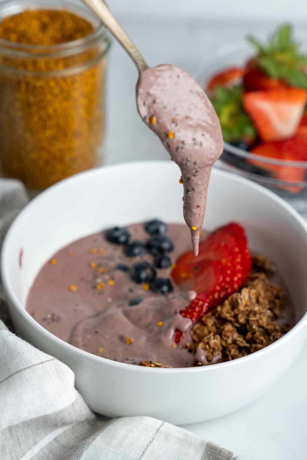 Spoon scooping from an acai protein bowl.