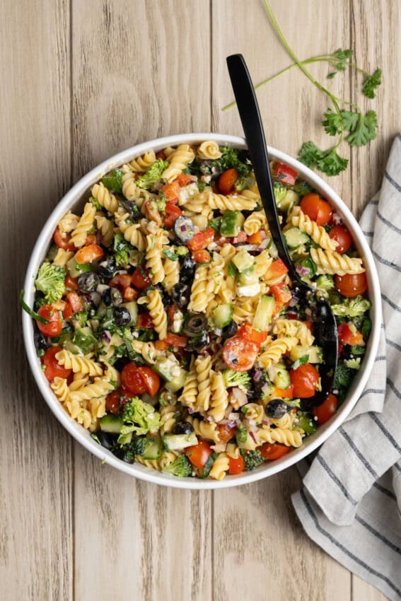 Serving spoon in a bowl of high protein pasta salad.