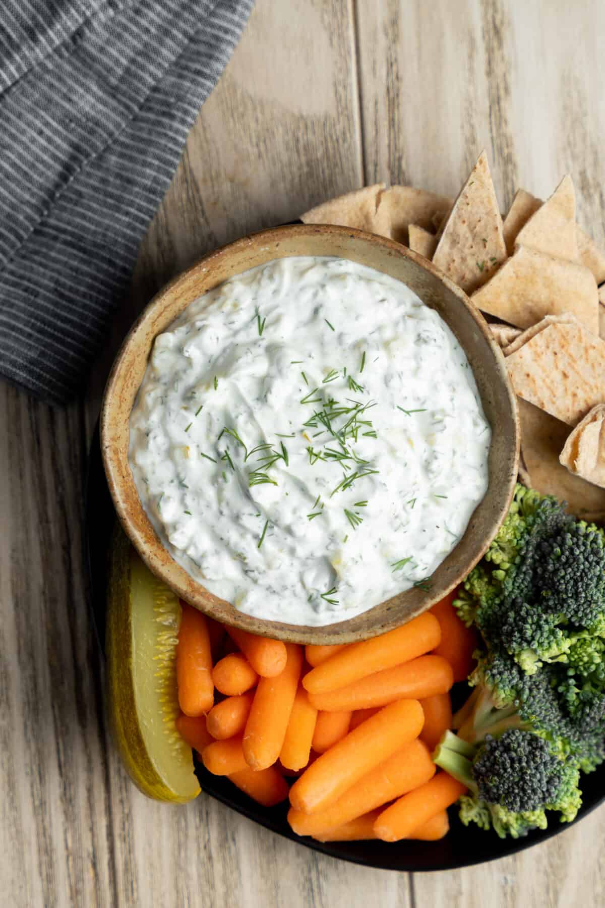 Bowl of dill pickle dip topped with fresh dill.