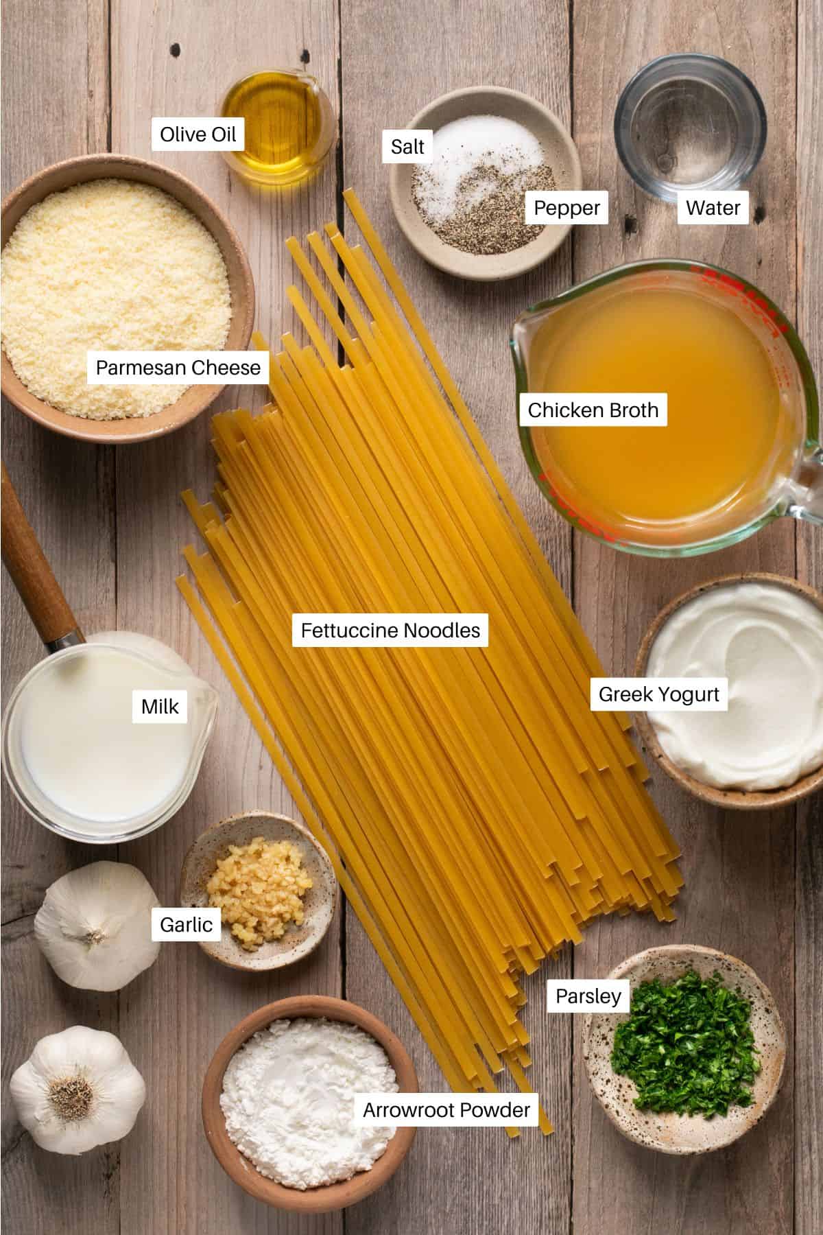 Oil, salt, pepper, water, broth, noodles, parmesan cheese, milk, greek yogurt, garlic, arrowroot and parsley for fettuccine alfredo in the instant pot. 