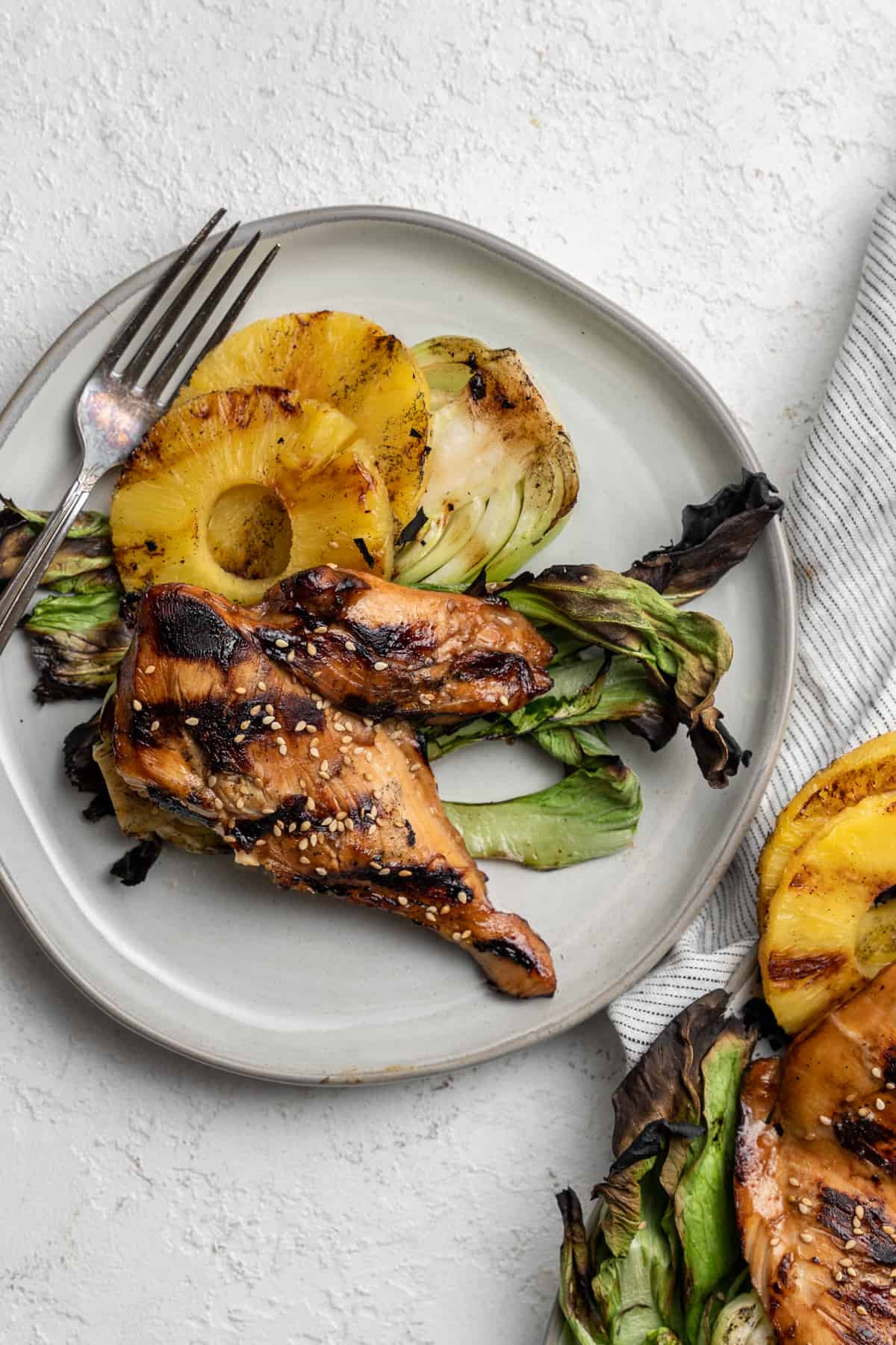 Plate of grilled teriyaki chicken, pineapple, and baby bok choy.