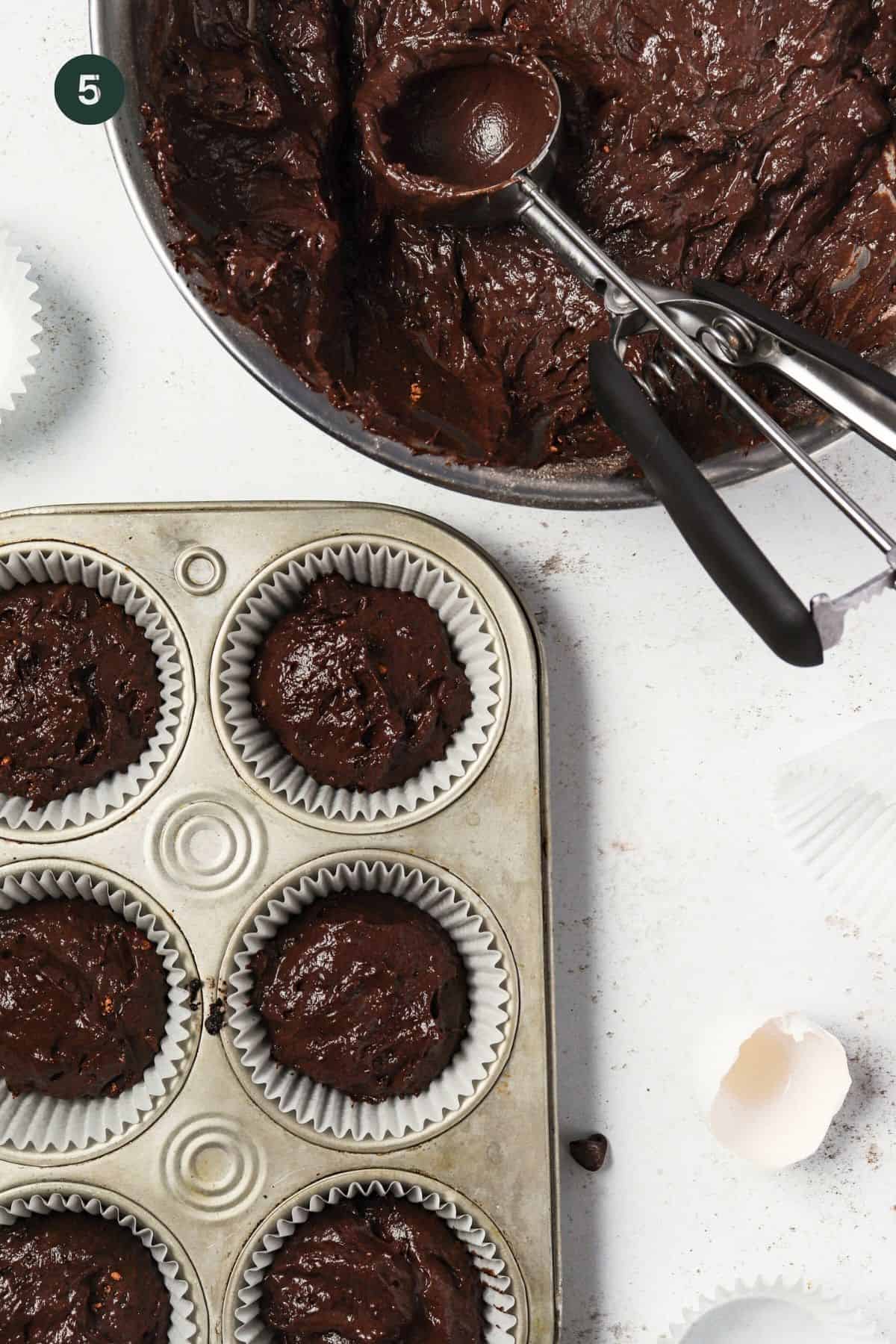 Batter added to a muffin tin to bake.