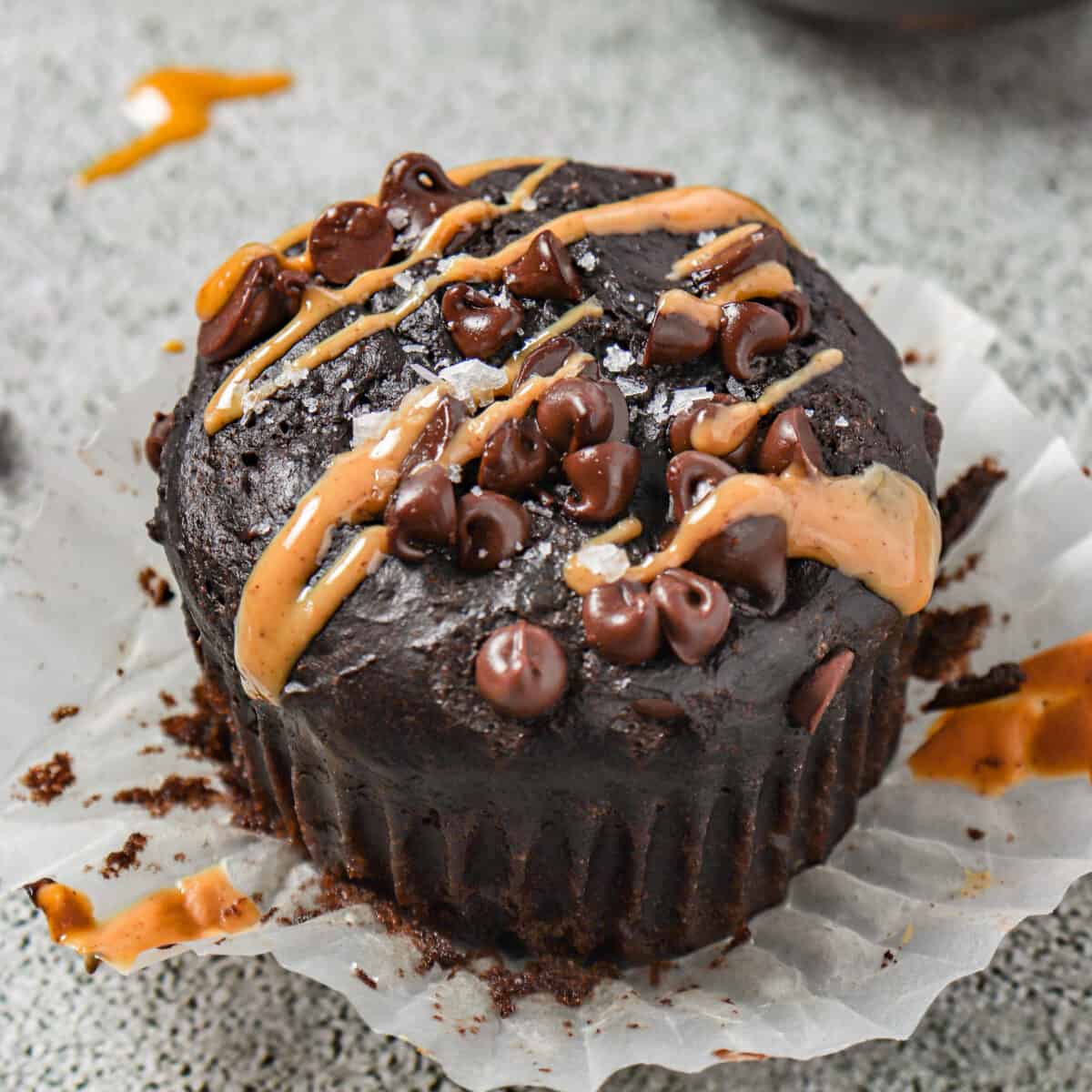 Chocolate muffins with chocolate chips, peanut butter and sea salt on top.