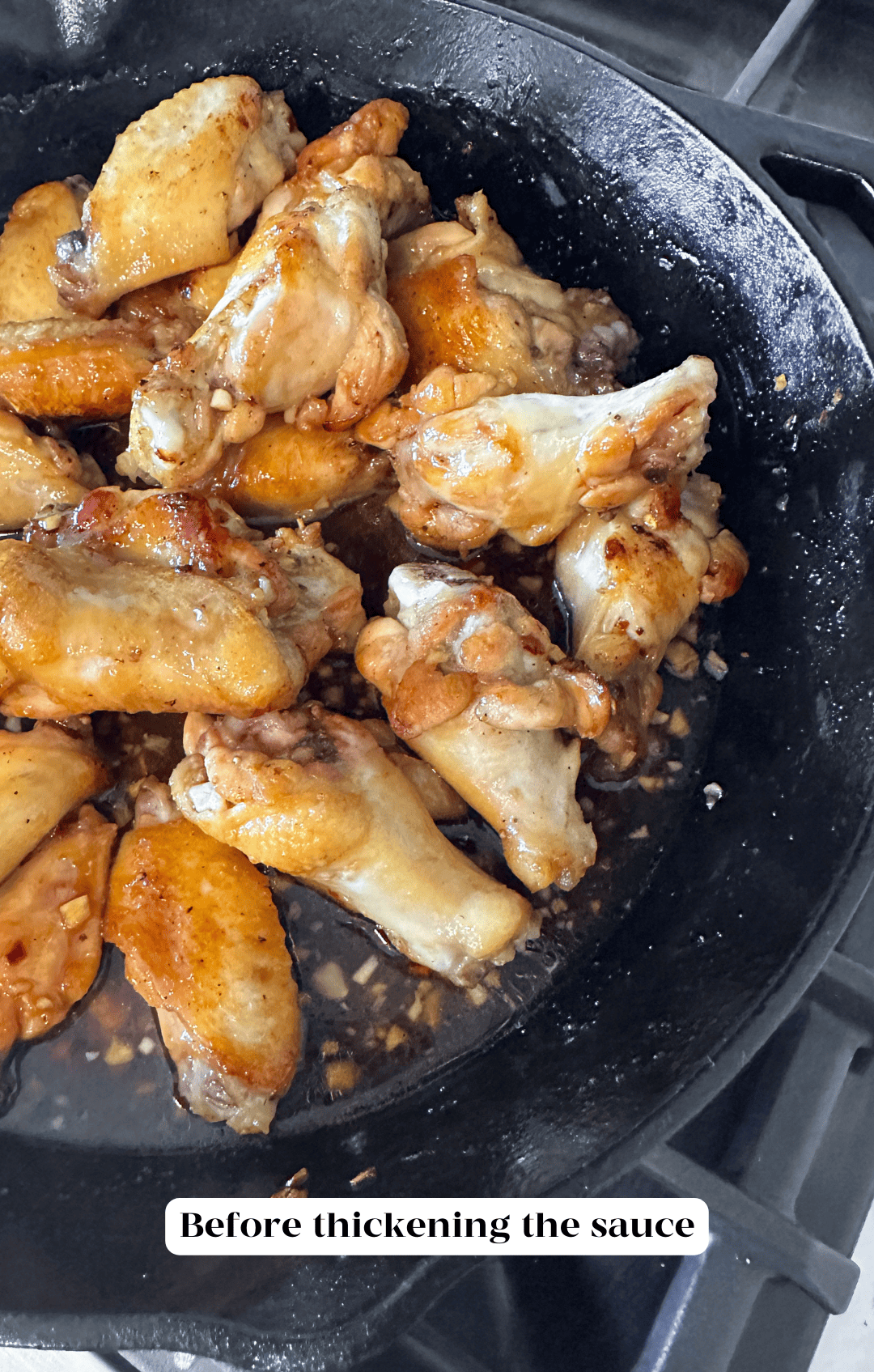 Plain wings piled in a pan with sauce.