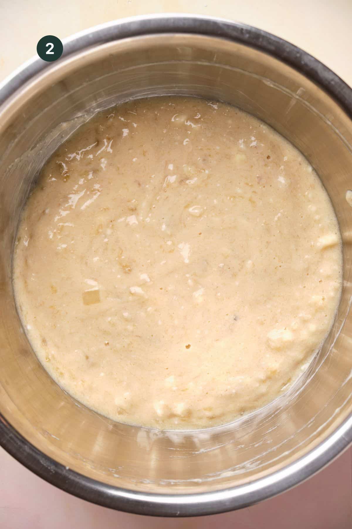 Fully combined wet ingredients for banana bread in a large bowl. 