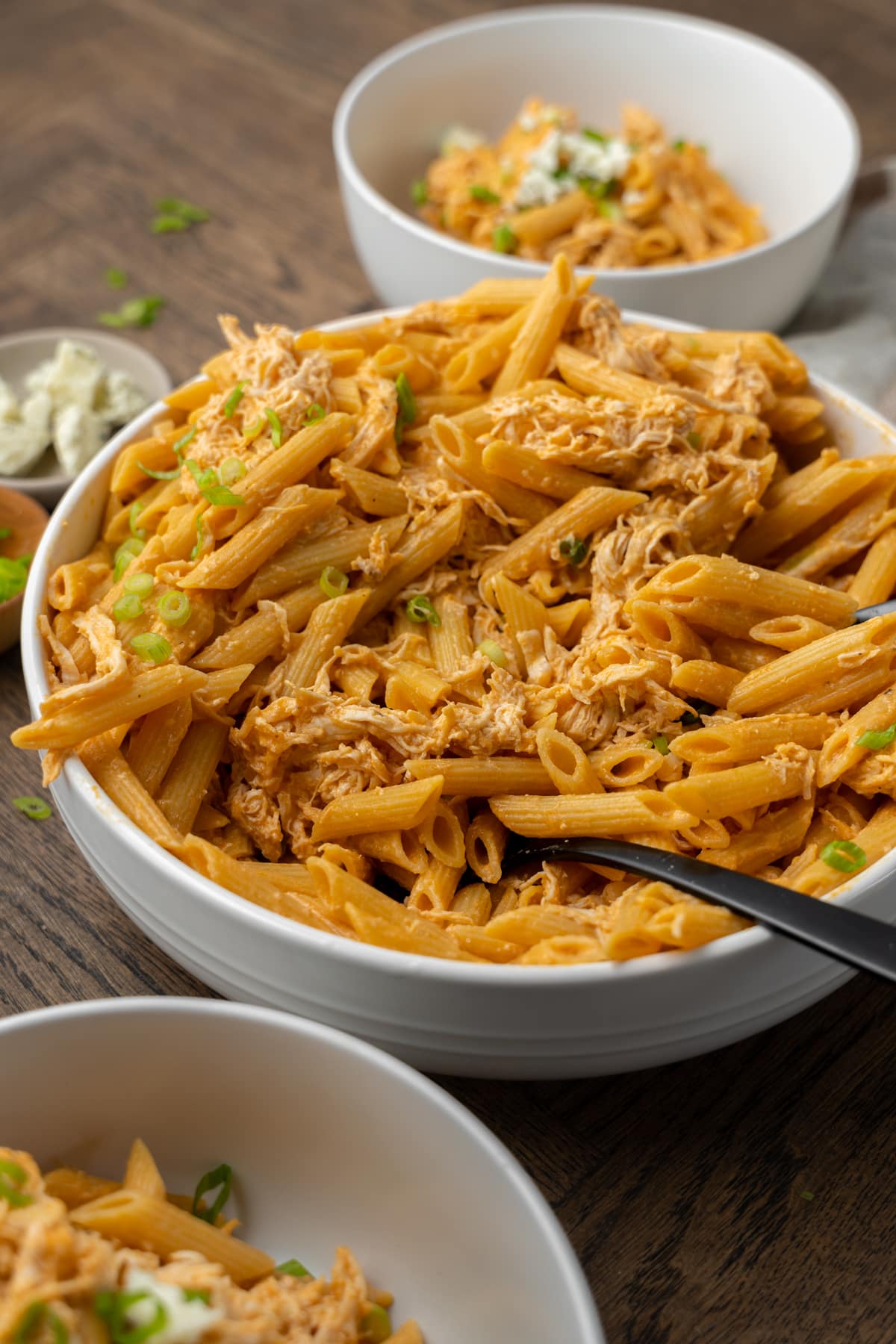 Spoon in a large bowl of buffalo chicken pasta.