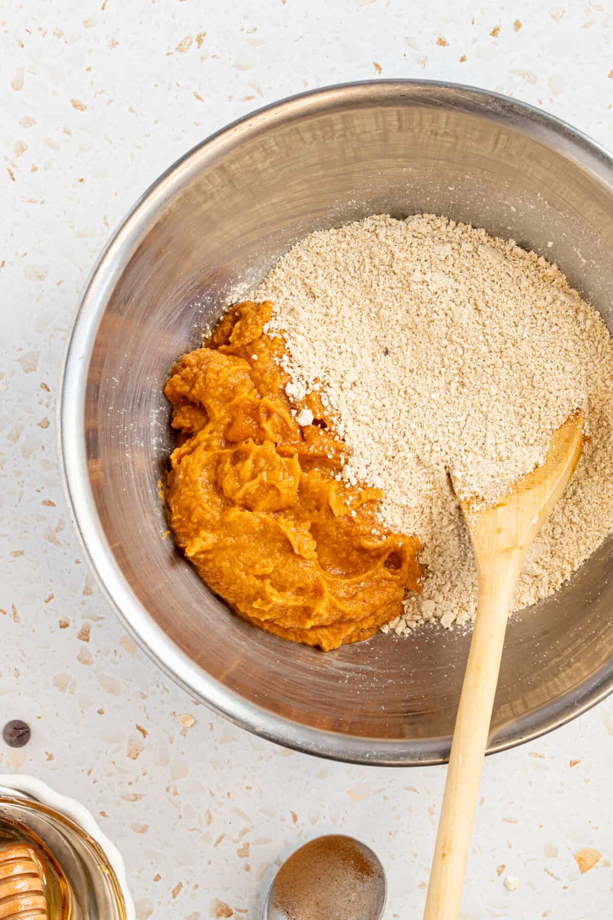Processed oats and pumpkin ingredients in a mixing bowl.
