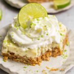 Key lime pie bar on a plate, missing a bite.