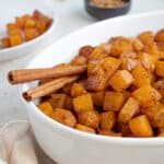 Cinnamon sticks in a bowl of butternut squash.