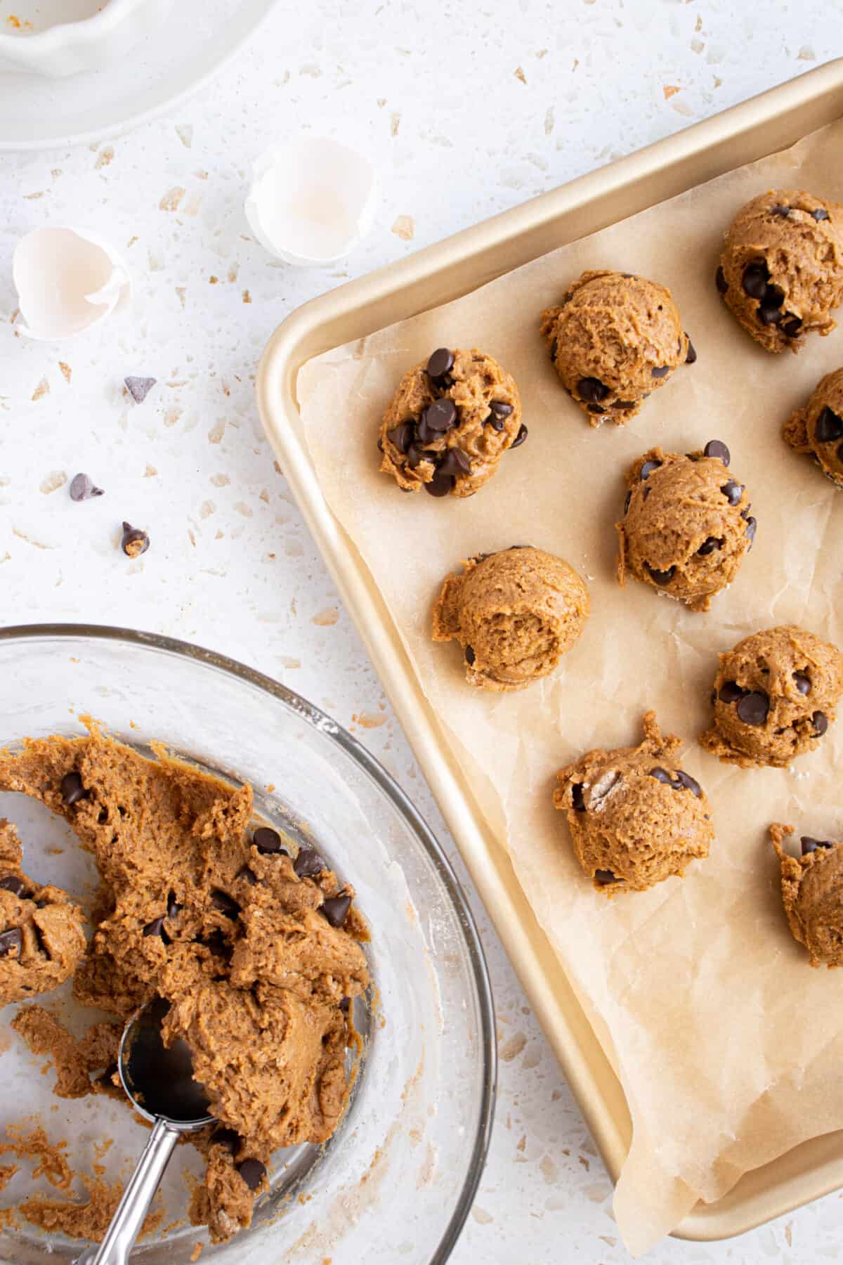 Cookies scooped into balls on a cookie sheet. 