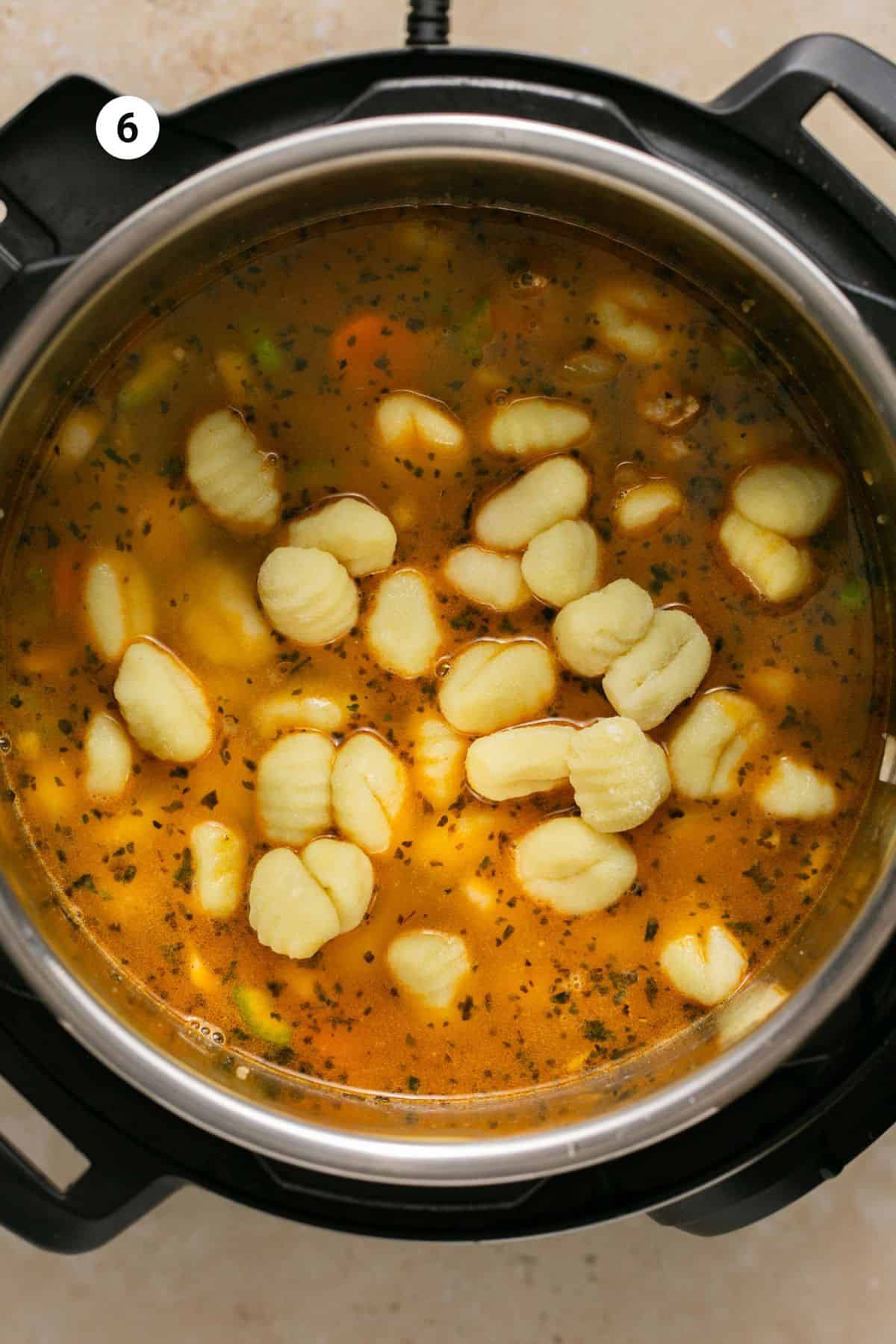 Gnocchi added to the pot of broth and vegetables.