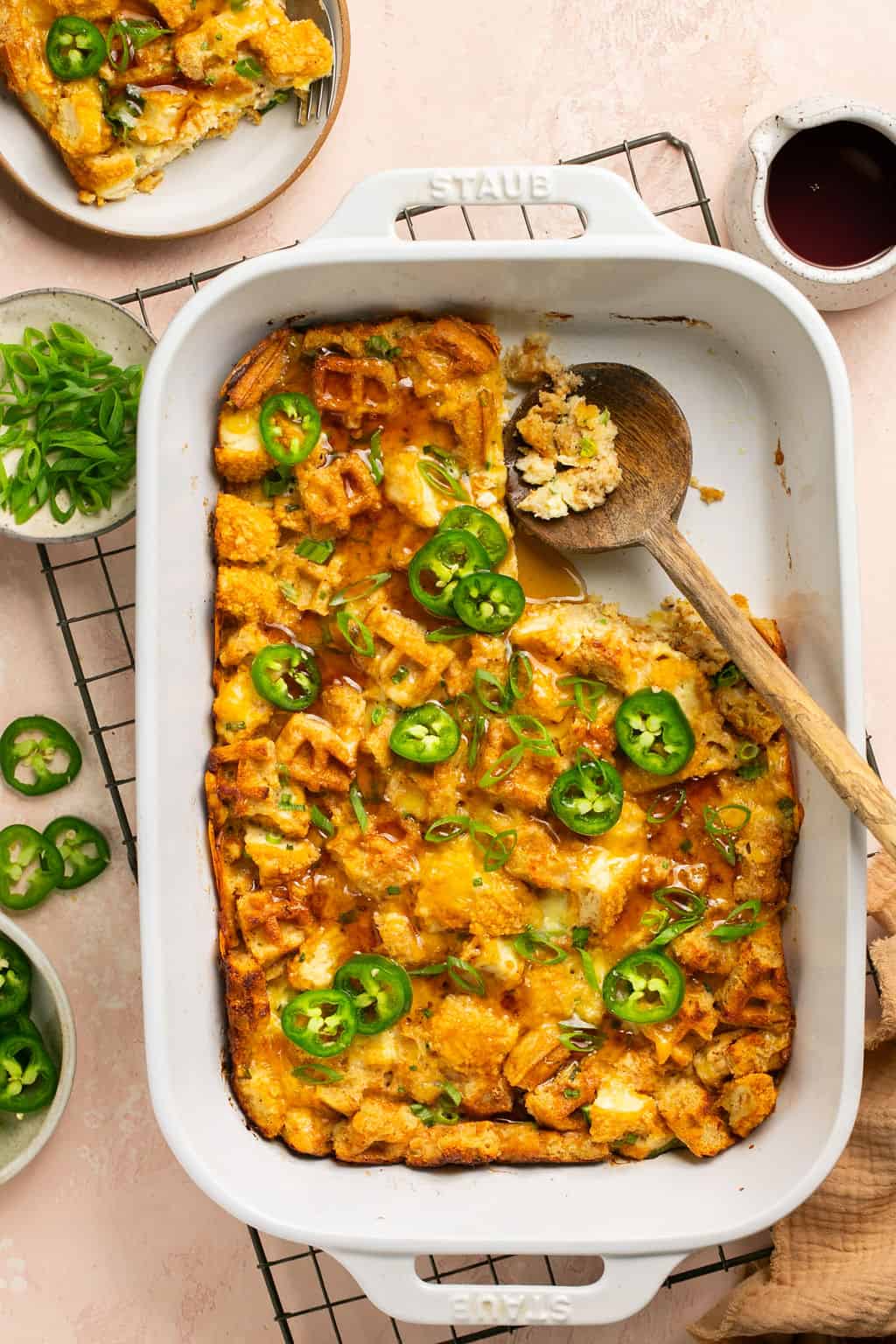 Fully baked chicken and waffle casserole with maple syrup and jalapenos on top.