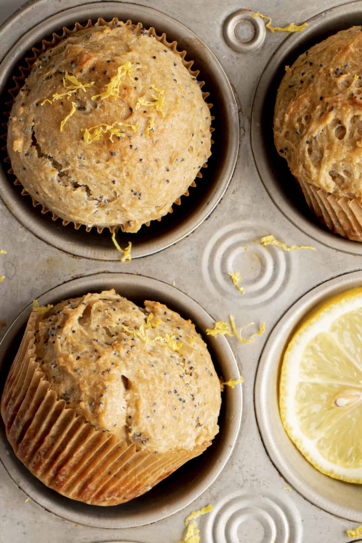 Lemon zest on muffins and a muffin tin.