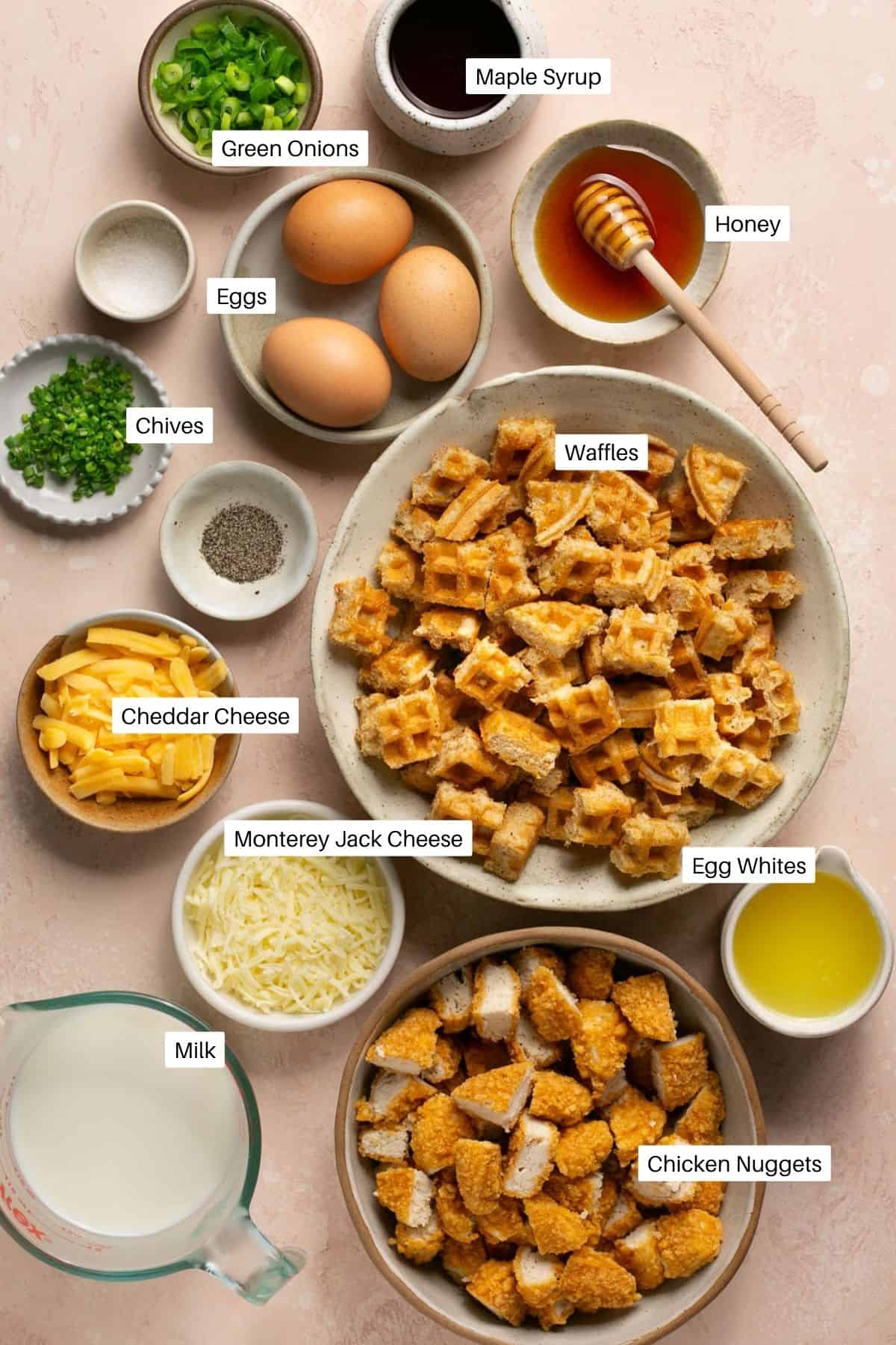 Ingredients for chicken and waffle casserole including cheeses, eggs, and honey.