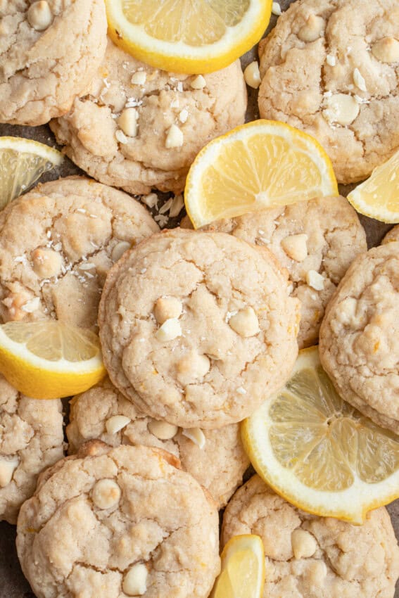 Pile of lemon white chocolate cookies and lemon slices.