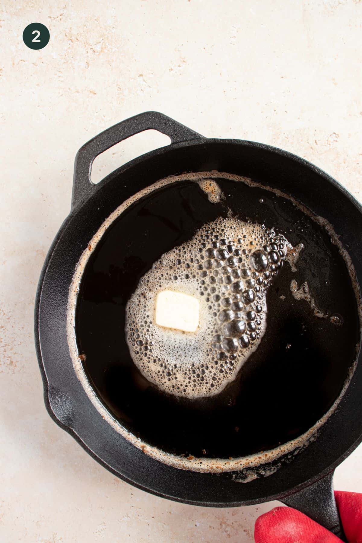 Butter melted in a cast iron skillet.