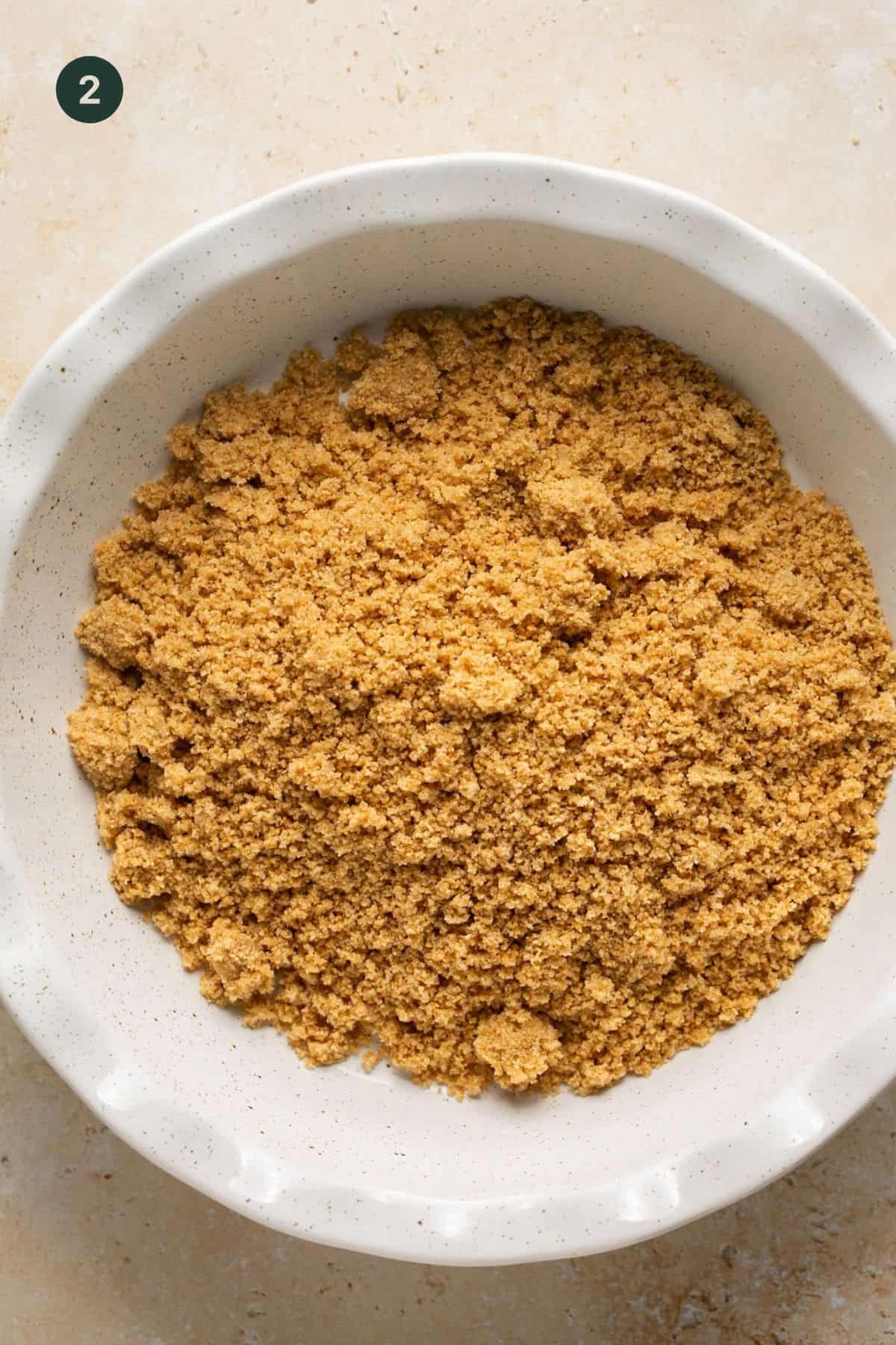 Graham crackers combined with coconut oil to resemble wet sand.