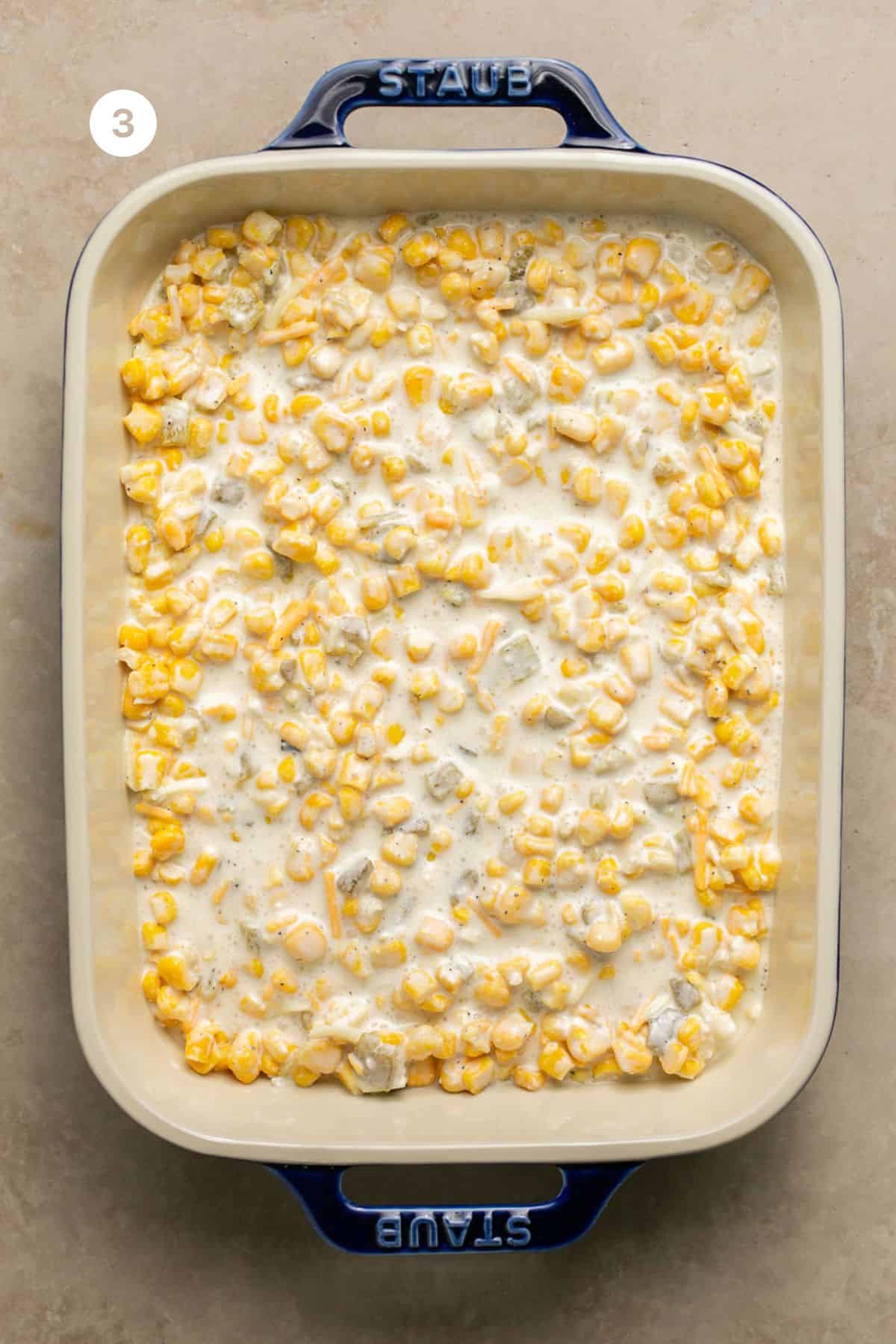 Creamy corn mixture added to a large baking dish. 