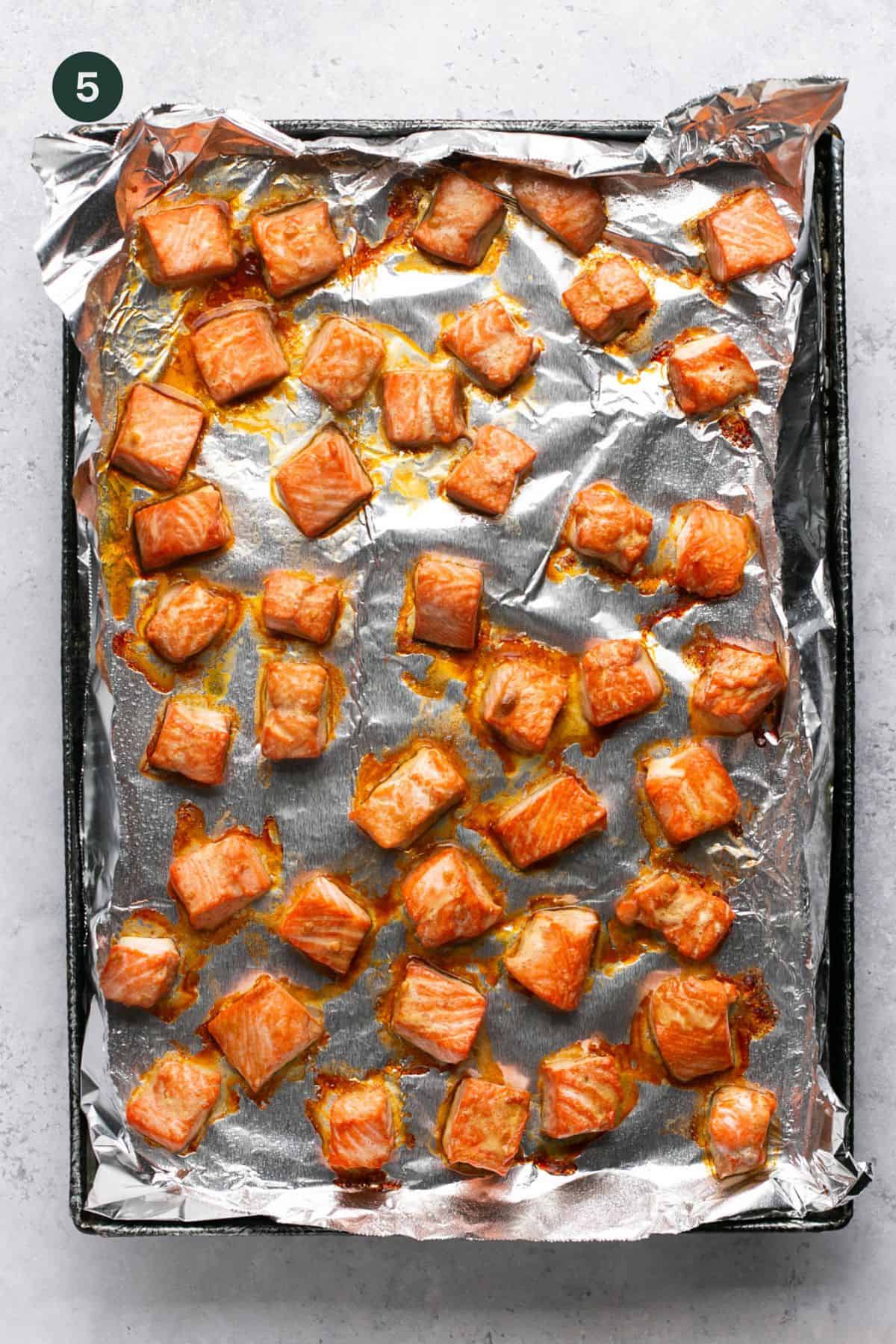Baked cubed salmon on foil lined baking sheet. 