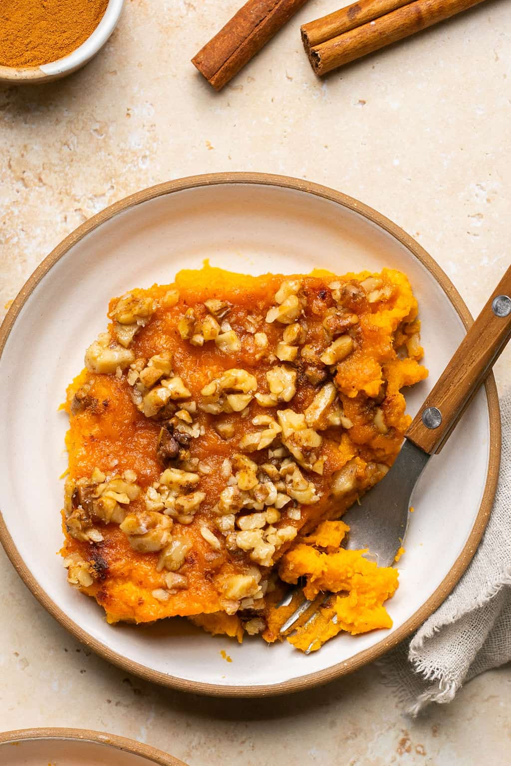 One serving of gluten free sweet potato casserole with walnut honey topping on a small plate. 