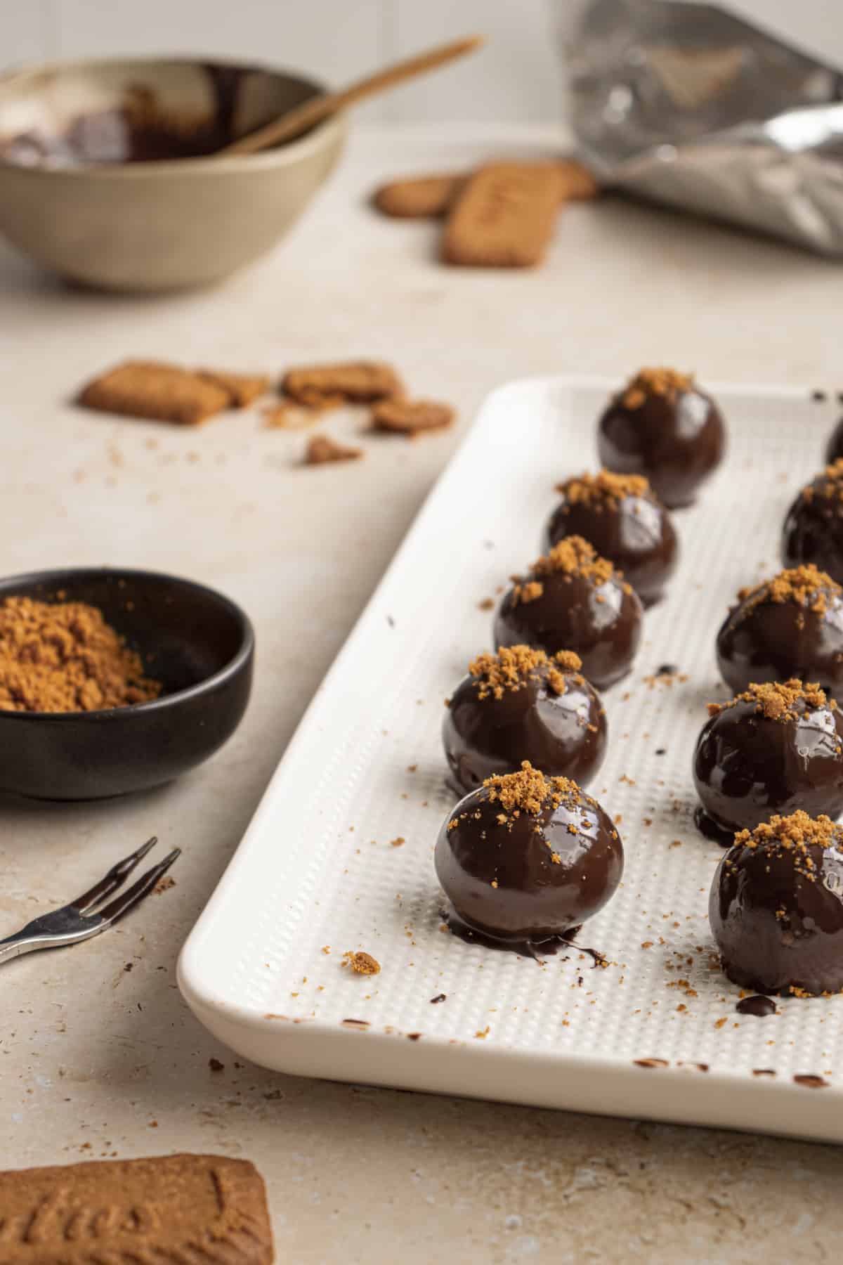 Truffles on a baking sheet with cookie crumbs on top. 