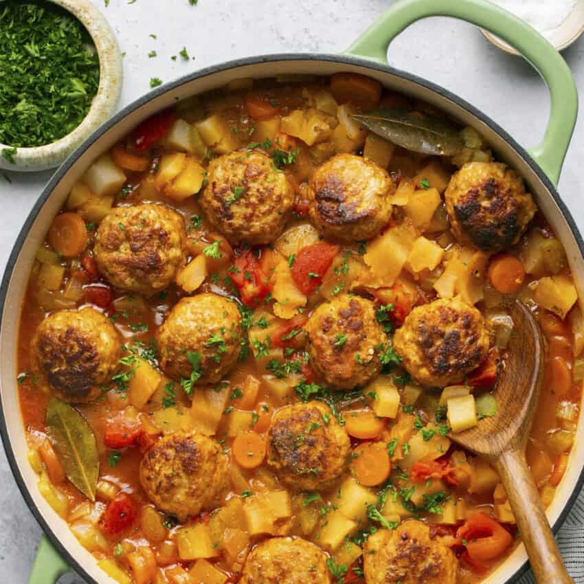 Light green Dutch oven of Cajun meatball stew.