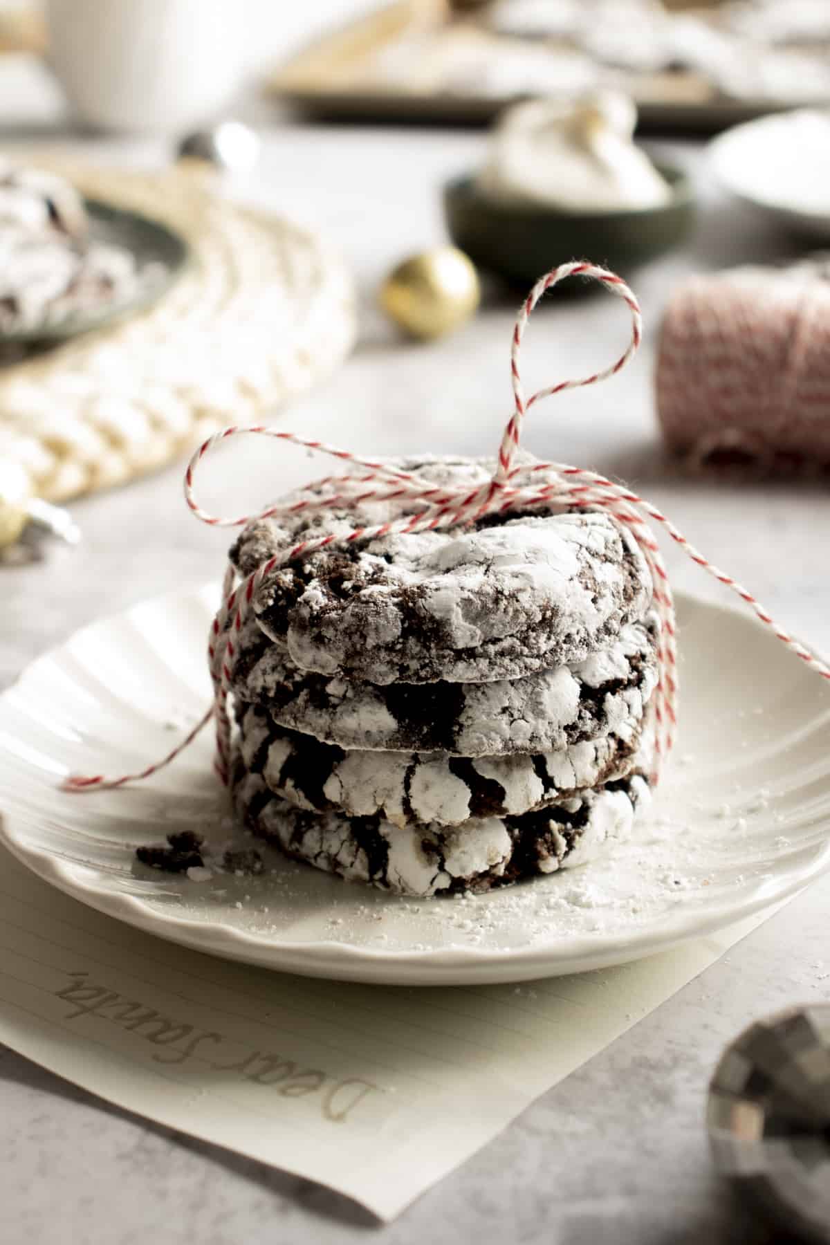 Stacked chocolate cookies tied with a bow and a letter to Santa under the plate they\'re sitting on. 